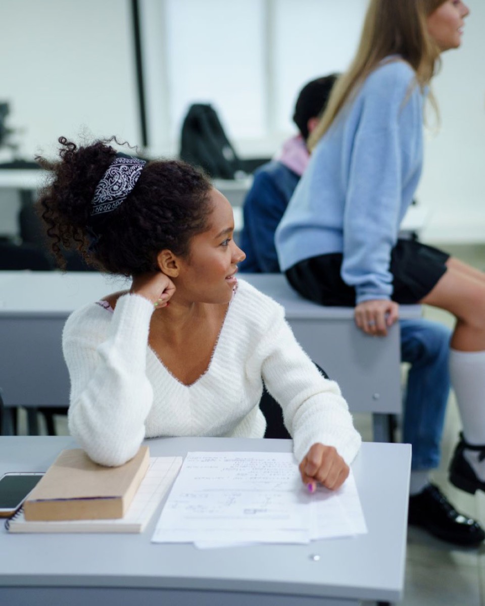 Student working through a worksheet at her desk in class